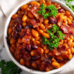 Delicious Homemade Baked Beans for Autumn Comforting homemade baked beans recipe with navy beans, bacon, and molasses, perfect for holiday gatherings.