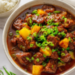 Slow cooked Sweet and Sour Beef with tender chunks of beef, vibrant bell peppers, and tangy pineapple in a rich sauce.