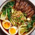 Delicious beef ramen noodles topped with fresh vegetables and soft-boiled eggs, perfect for a cozy meal.